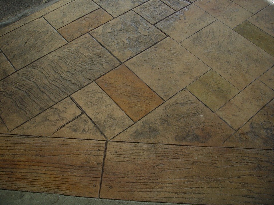 Close-up of a stamped concrete surface with stone-like texture and a patterned border
